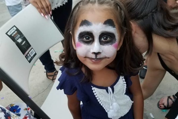 Una niña tiene la cara pintada de panda. Joy of Life Subrogación