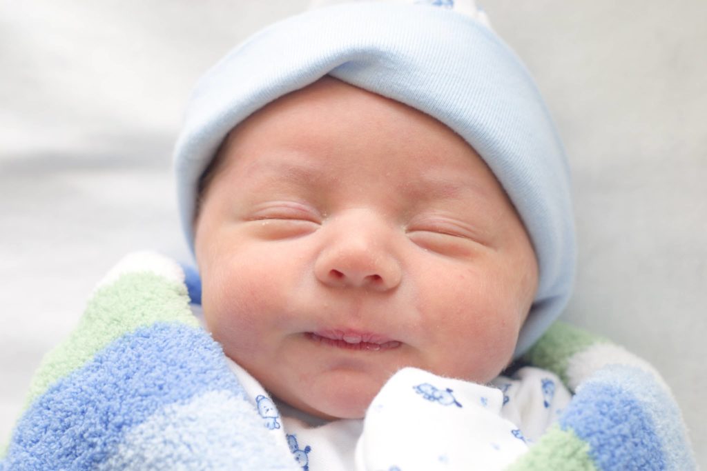 bebé recién nacido sonriendo - Joy of Life Subrogación
