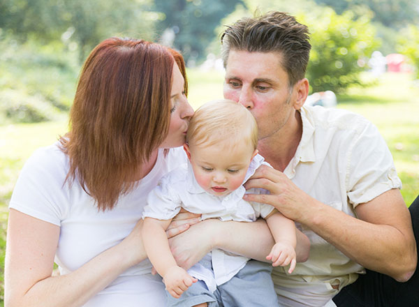 Futuros padres besando a su bebé. Joy of Life Subrogación