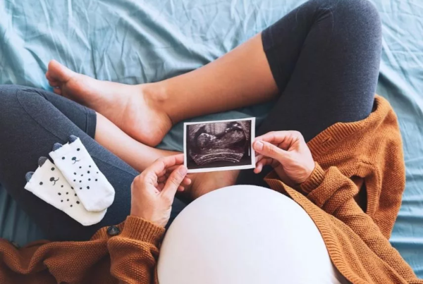 A Surrogate mom looking at a picture - Joy of Life Surrogacy