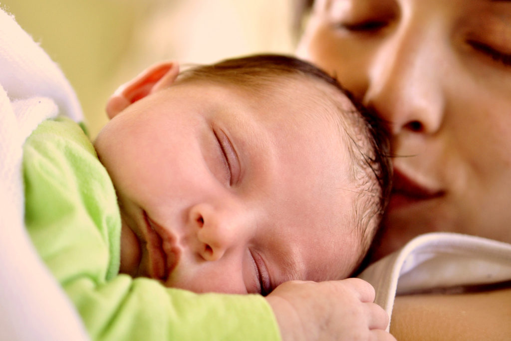 Un bebé recién nacido yacía sobre el pecho de su madre. Joy of Life® Subrogación