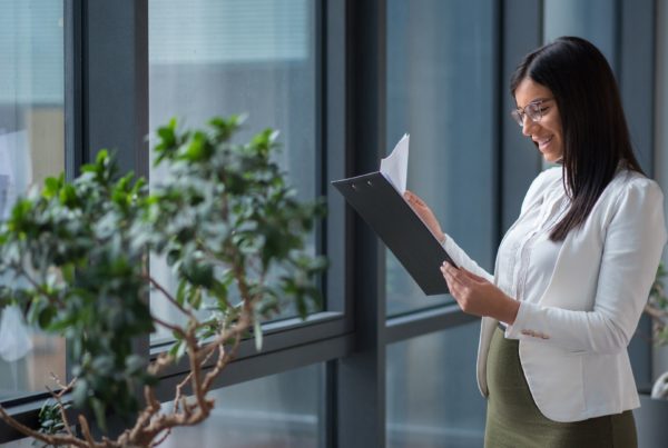 A Pregnant Mother checking the contract in her office - Joy of Life Surrogacy