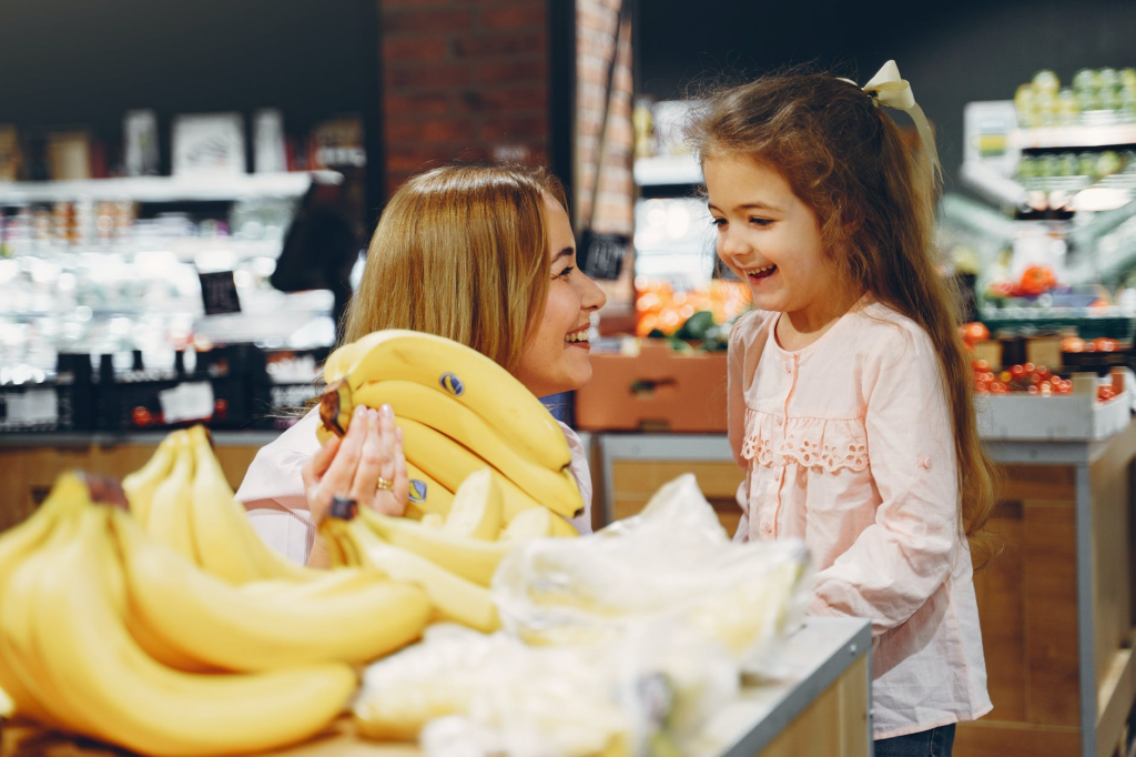 Mamá e hija paradas frente a un plátano. Joy of Life Subrogación