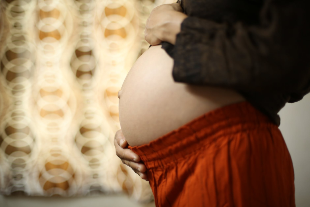 怀孕的妈妈摸着她的肚子—— Joy of Life® 代孕