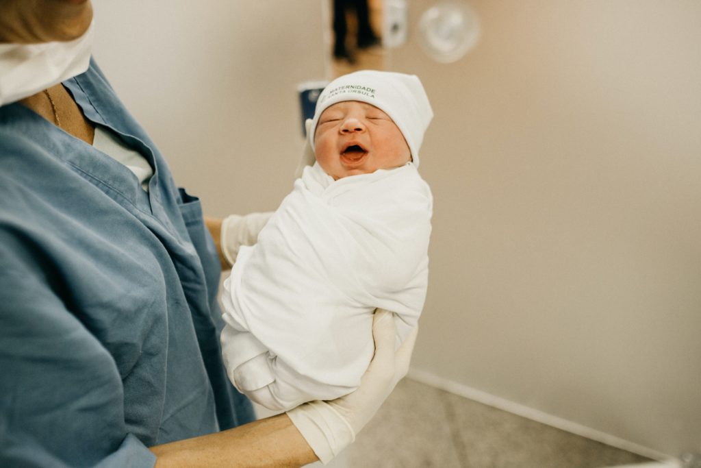 Mamá sostiene a su bebé recién nacido. Joy of Life® Subrogación, agencias de subrogación California