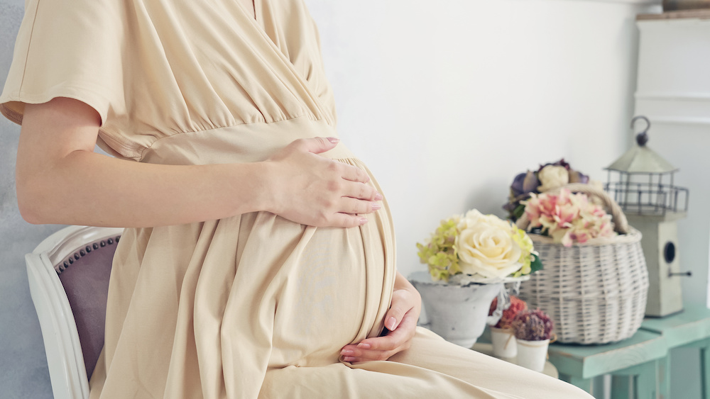 A pregnant woman reclining and holding her stomach