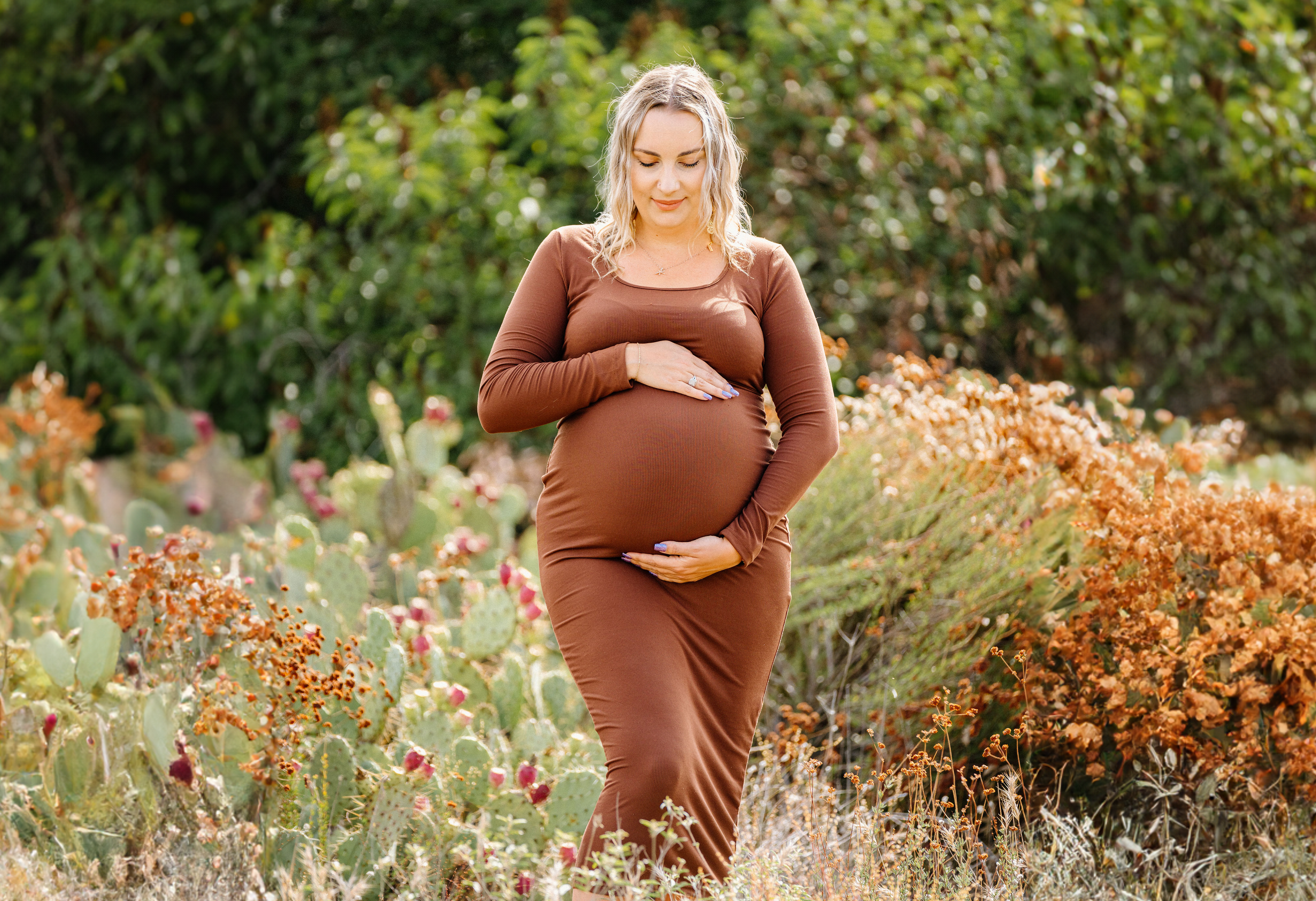 Pregnant surrogate mother holding her baby bump