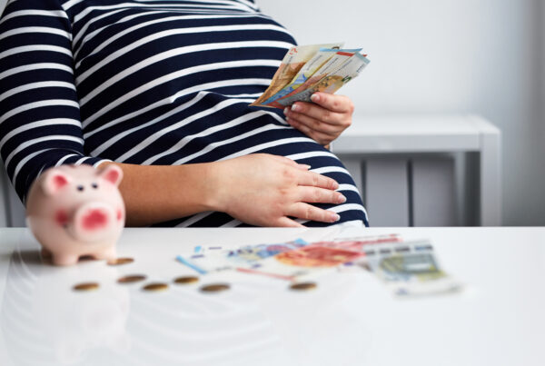 A surrogate mother in a striped dress sitting at a table with a piggy bank, budgeting funds from her surrogacy compensation for taxes and expenses.